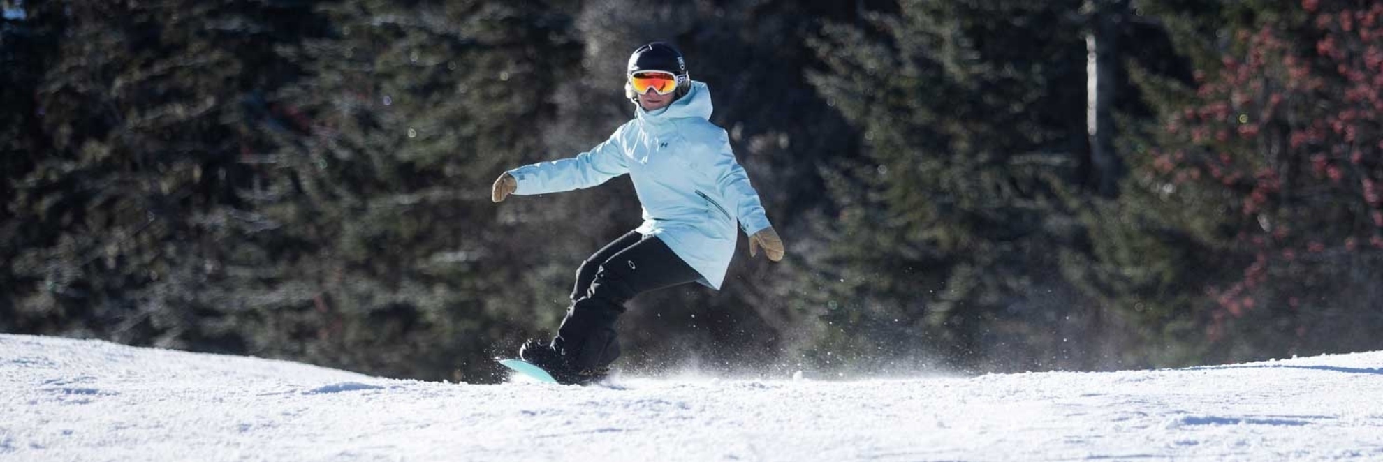 female snowboarder carving a turn